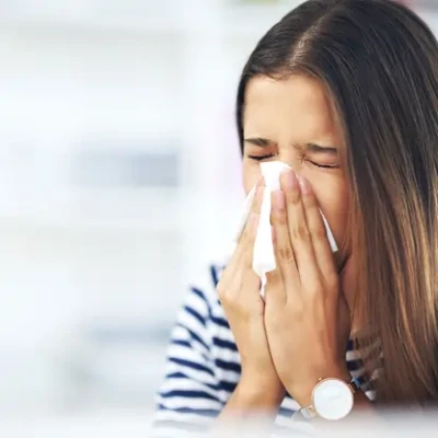 a woman showing common allergy symptoms triggered by air pollution in urban areas